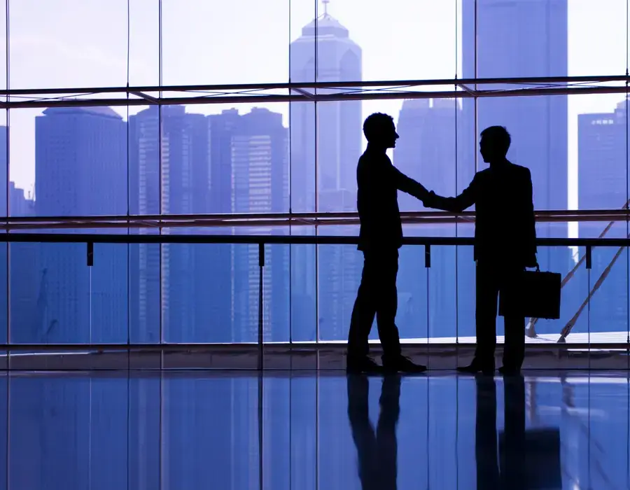 Dos hombres de negocios a contraluz frente a rascacielos
