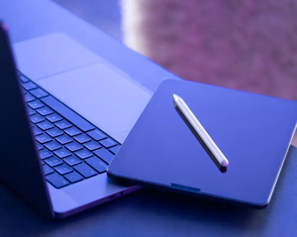 Ordenador y ipad sobre mesa azul